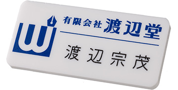 ロゴマーク等をシルク印刷し､後から名前を彫刻した名札（正面から見た画像）