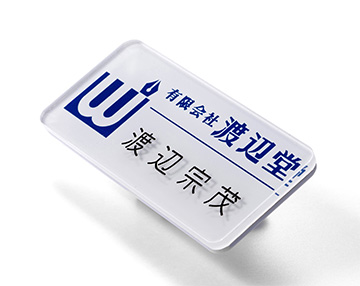 ロゴマーク等を透明プレートの裏側からシルク印刷し､後から名前をプレートの表面に彫刻した名札